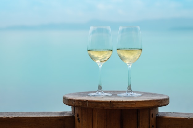 Primo piano due bicchiere di vino bianco sul tavolo sulla terrazza sul mare