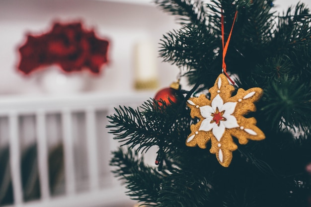 Primo piano e vista di taglio della decorazione sull'albero di Natale a forma di fiocco di neve. La camera è su sfondo sfocato.