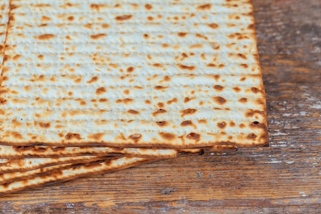 Primo piano ebreo di matzah di kosher su carta su una tavola di legno. vista orizzontale