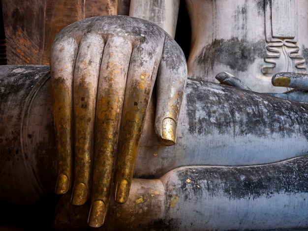 Primo piano enorme mano dell'antica statua del Buddha all'interno della chiesa del tempio Wat Sri Chum, il famoso punto di riferimento del Parco storico di Sukhothai, patrimonio mondiale dell'UNESCO in Thailandia.