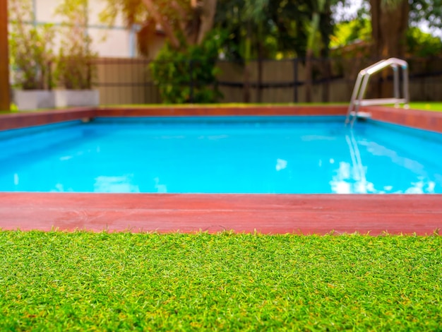 Primo piano erba verde sulla piscina all'aperto sullo sfondo