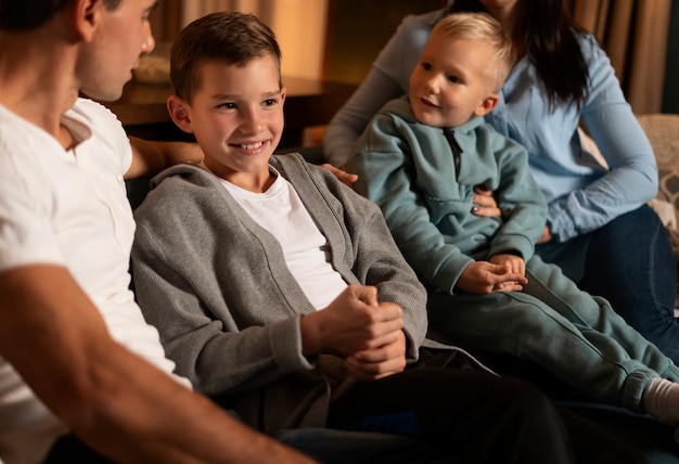 Primo piano famiglia felice seduta a casa