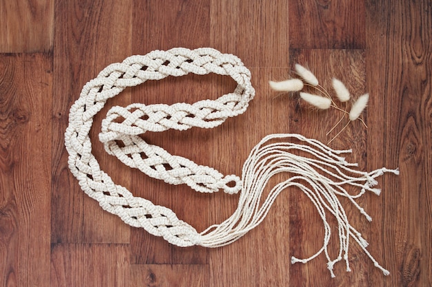 Primo piano fatto a mano della cintura del vestito dal macrame. Fili di cotone naturale.