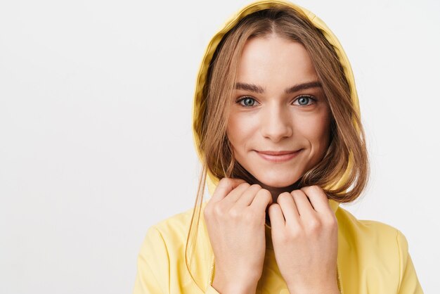 Primo piano fotografico di una bella donna gioiosa in impermeabile che guarda l'obbiettivo e sorride