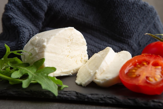 Primo piano fresco e gustoso della mozzarella Sfondo grigio cemento