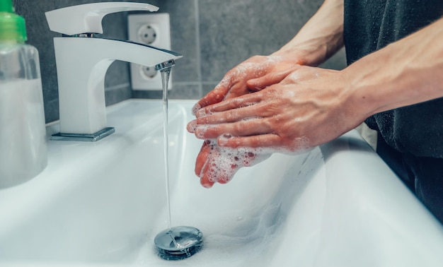 Primo piano giovane che usa un sapone antisettico