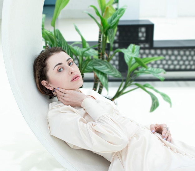 Primo piano grazioso della giovane donna sul muro bianco del mattone