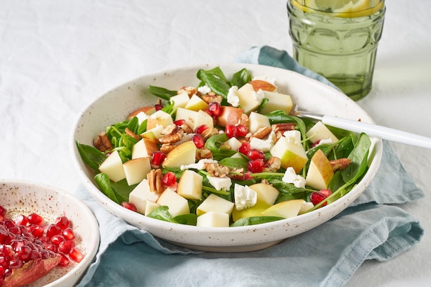 Primo piano Insalata di frutta con noci, cibo equilibrato, mangiare pulito. Spinaci con mele, noci pecan e feta