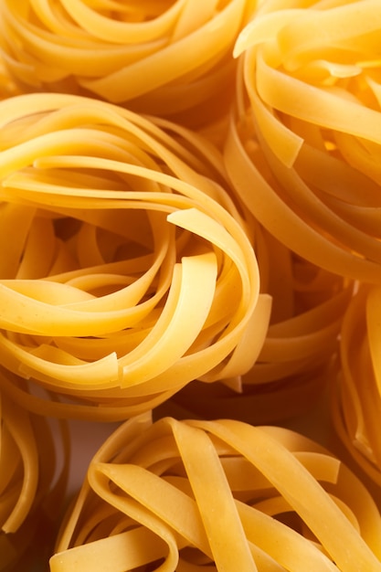 Primo piano italiano del nido della pasta all'uovo. Fettuccine sfondo