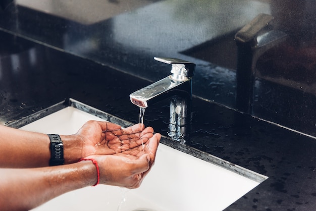 Primo piano lavarsi le mani strofinando con acqua e sapone nei lavandini per prevenire l'igiene del coronavirus