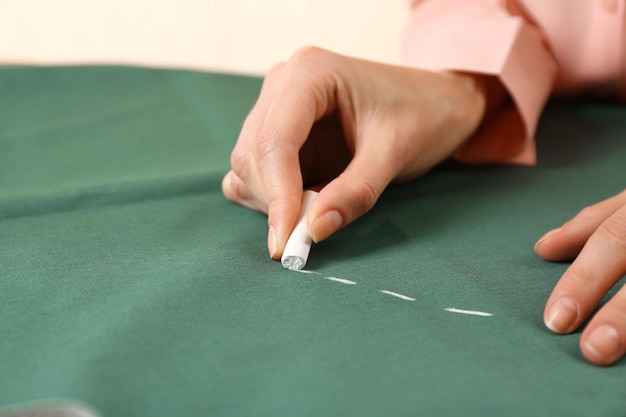 Primo piano le mani della sarta al lavoro con tessuto di stoffa