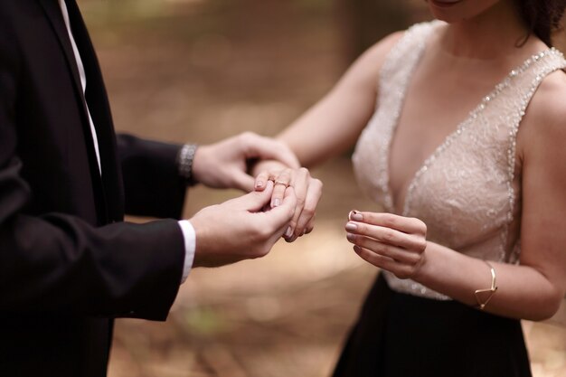 Primo piano, lo sposo mette l'anello nuziale al dito della sposa