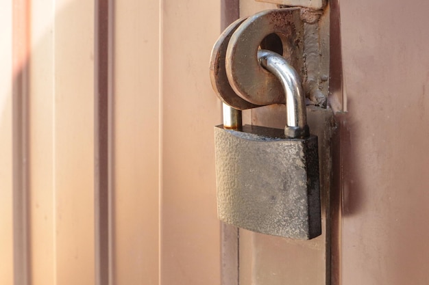 Primo piano lucchetto sul cancello di un recinto di metallo marrone fatto di moderno schierandosi il concetto di sicurezza