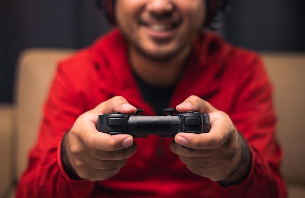 Primo piano mani maschili che tengono console di gioco joystick Giovane uomo che gioca a videogiochi online
