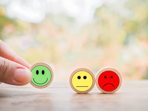Primo piano mano che organizza il blocco di legno del viso felice Valutazione del servizio clienti esperienza feedback emozione e sondaggio sulla soddisfazione