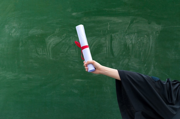 Primo piano mano che tiene il certificato di laurea