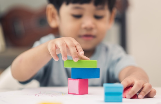 Primo piano Mano dei bambini Pratica le abilità di giocare con i giocattoli di legno sul tavolo in soggiorno Educazione asiatica del ragazzino da casa Sviluppare l'apprendimento dei bambini prima di entrare nella scuola materna