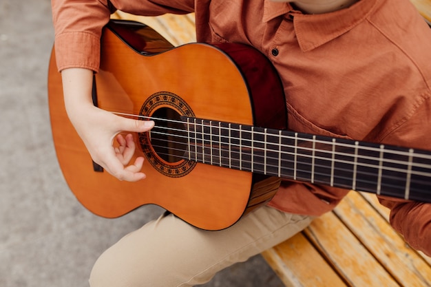 Primo piano, mano del bambino con la chitarra, all'aperto, chitarra classica