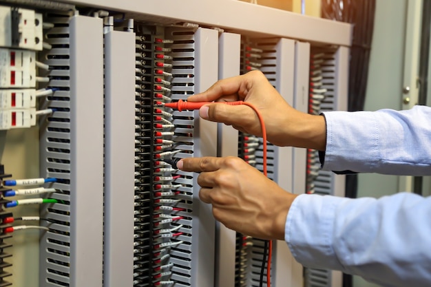 Primo piano mano di ingegneria elettrica utilizzando la misurazione per controllare l'elettricità.