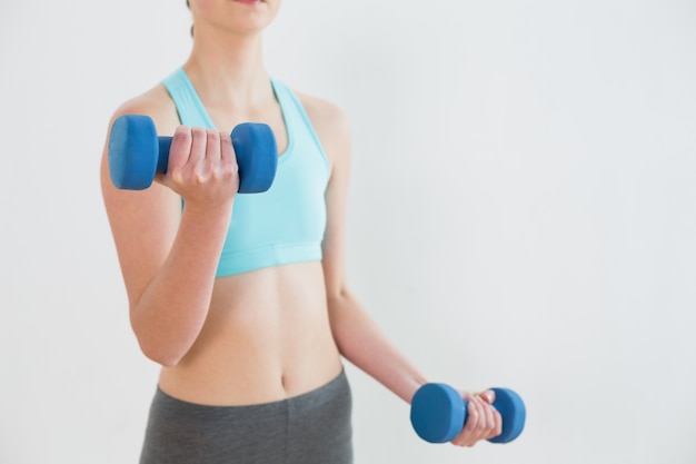 Primo piano metà sezione della donna con manubri