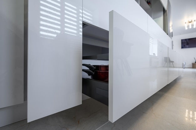 Primo piano moderno bianco della cucina ai cassetti più bassi tirati fuori
