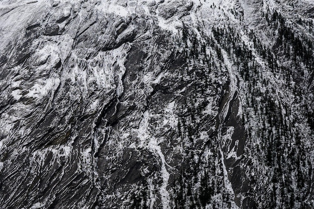 Primo piano Montagna rocciosa stagionata con motivo di neve sulla trama