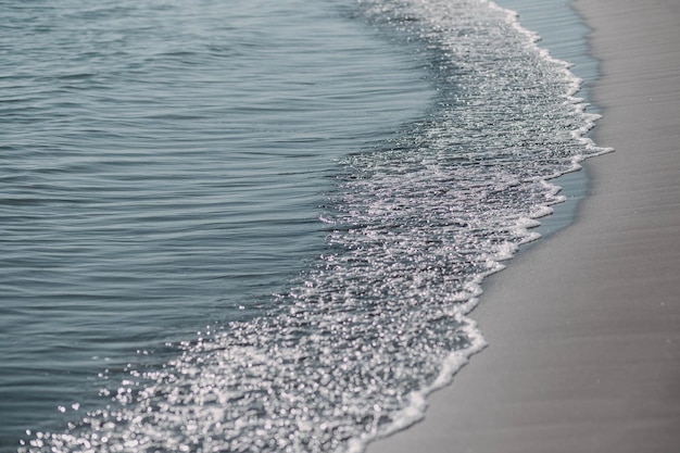 Primo piano morbida onda del mare sulla spiaggia sabbiosa