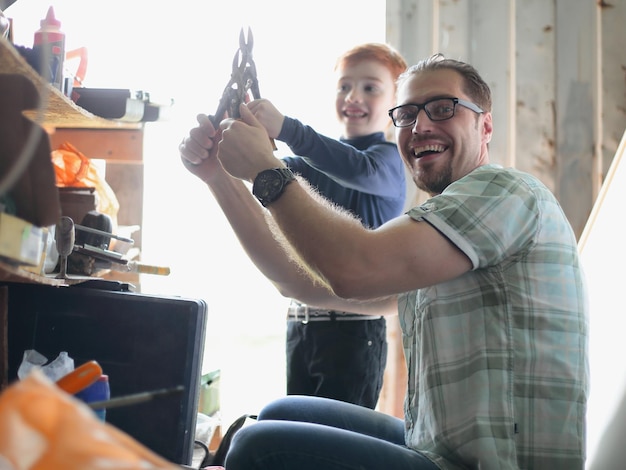 Primo piano padre felice, suo figlio piccolo stanno lavorando insiemeil concetto di educazione familiare