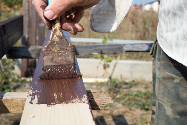 Primo piano pennello in mano e pittura sul tavolo di legno