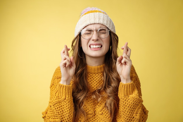 Primo piano preoccupato estremamente nervoso ragazza nerd carina studentessa universitaria che prega sforzandosi che il sogno si avveri...