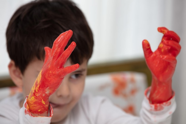 Primo piano ragazzo dipinto con mani colorate Creatività artistica e concetto di pittura