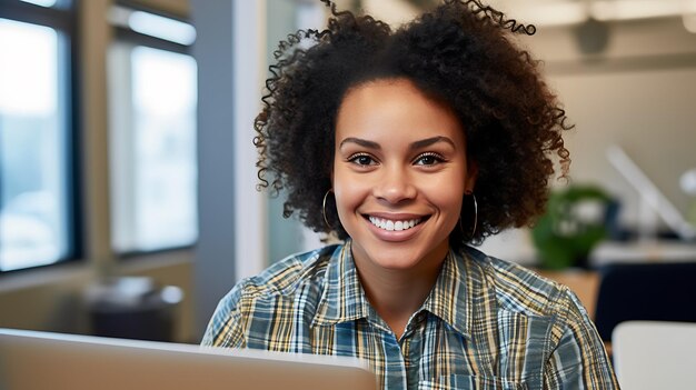 Primo piano ritratto di giovane bella donna afroamericana sorridente mentre si lavora con il computer portatile in ufficioCreato con la tecnologia generativa AI