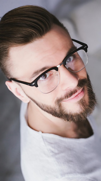 Primo piano Ritratto di un uomo d'affari barbuto sorridente ed elegante che indossa occhiali che guarda direttamente nella fotocamera