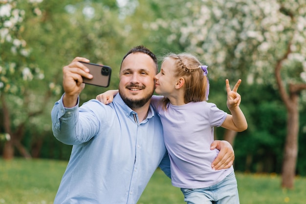 Primo piano ritratto di una famiglia felice di due papà e figlia sorridenti prendono un selfie con lo smartphone