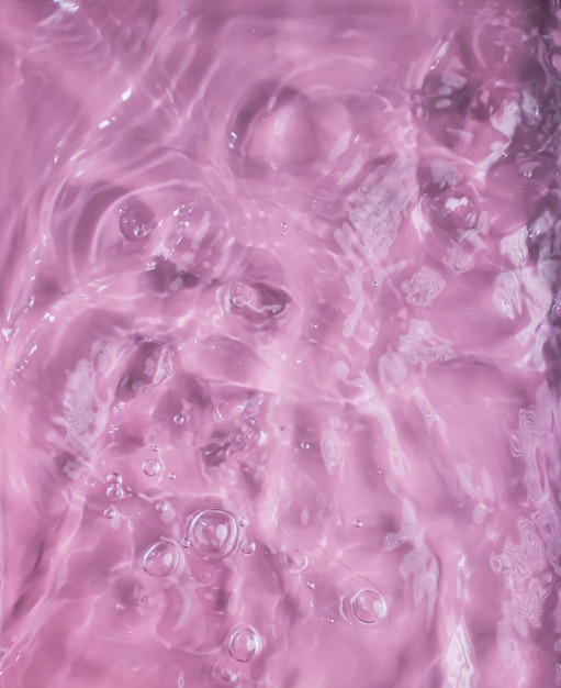 Primo piano rosa acqua chiara superficie texture con onde e schizzi e bolle Sfondo della natura estiva