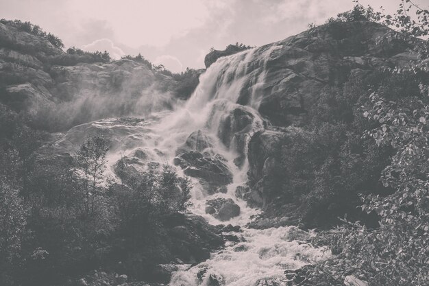 Primo piano scene di cascata in montagna, parco nazionale Dombai, Caucaso, Russia, Europa. Paesaggio estivo, tempo soleggiato, cielo azzurro drammatico e giornata di sole