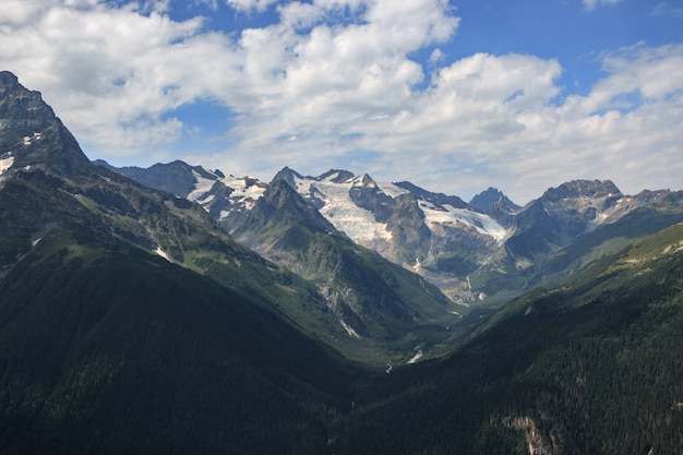 Primo piano scene di montagne nel parco nazionale Dombai, Caucaso, Russia, Europa. Paesaggio estivo, tempo soleggiato, cielo azzurro drammatico e giornata di sole