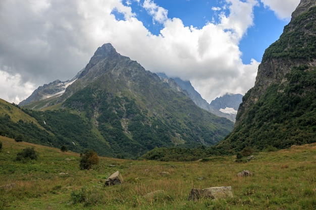 Primo piano scene di montagne nel parco nazionale Dombai, Caucaso, Russia, Europa. Paesaggio estivo, tempo soleggiato, cielo azzurro drammatico e giornata di sole