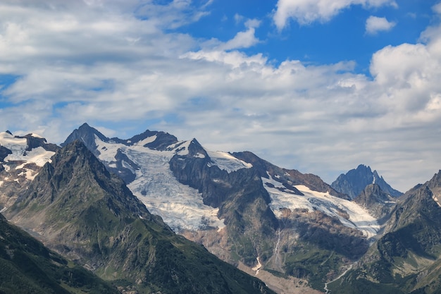 Primo piano scene di montagne nel parco nazionale Dombai, Caucaso, Russia, Europa. Paesaggio estivo, tempo soleggiato, cielo azzurro drammatico e giornata di sole