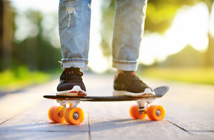 Foto primo piano skateboard. donna sportiva attiva divertendosi nel parco