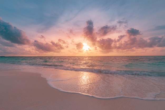 Primo piano spiaggia di sabbia del mare Paesaggio della spiaggia al tramonto Raggi di sole dorati arancioni costa tropicale del paesaggio marino della sabbia