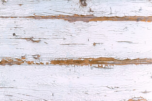 Primo piano, struttura della vernice bianca scrostata dal legno.