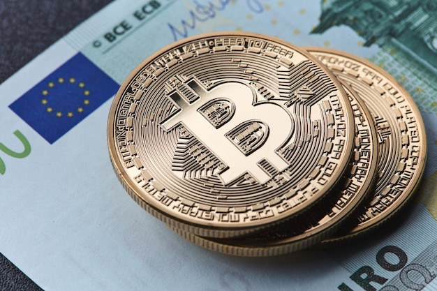 Primo piano su banconote in euro e monete d'oro bitcoin