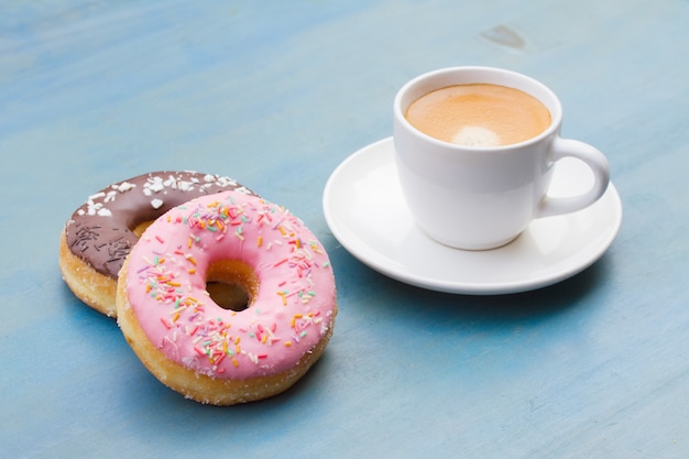 Primo piano su ciambelle fresche, che accanto alla tazza di caffè