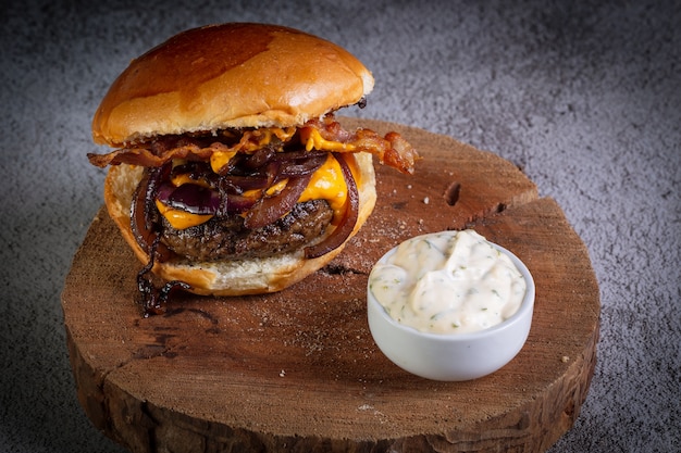 Primo piano su hamburger con formaggio cheddar e salsa all'aglio