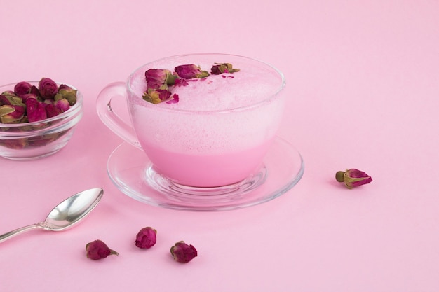 Primo piano su rose moon latte in tazza di vetro con petali