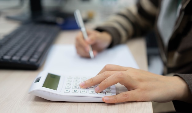 Primo piano sul dito mano premere sulla calcolatrice per il calcolo per il concetto di donna lavoratrice