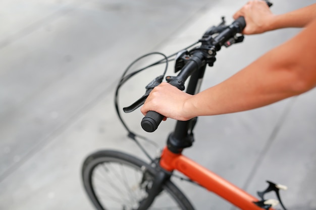 Primo piano sul manubrio con la mano femminile. Stile di vita sano e concetto di sport