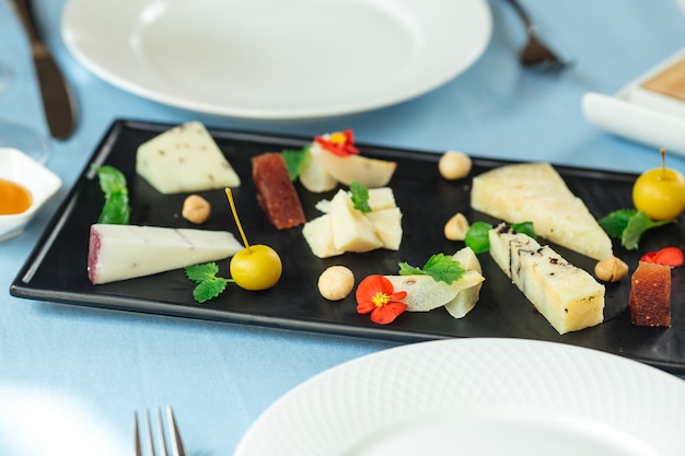 Primo piano sul piatto di formaggi spagnoli assortiti sul tavolo blu