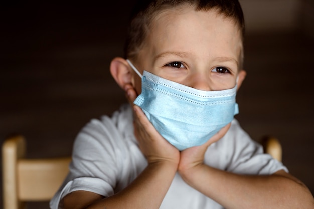 Primo piano sul ragazzo seduto in una maschera medica